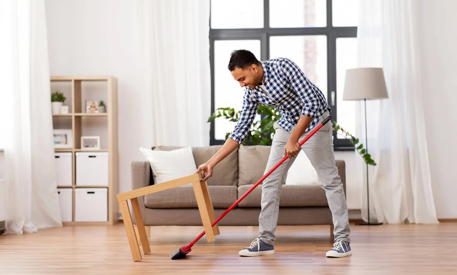 Sweeping vinyl flooring in a bright home