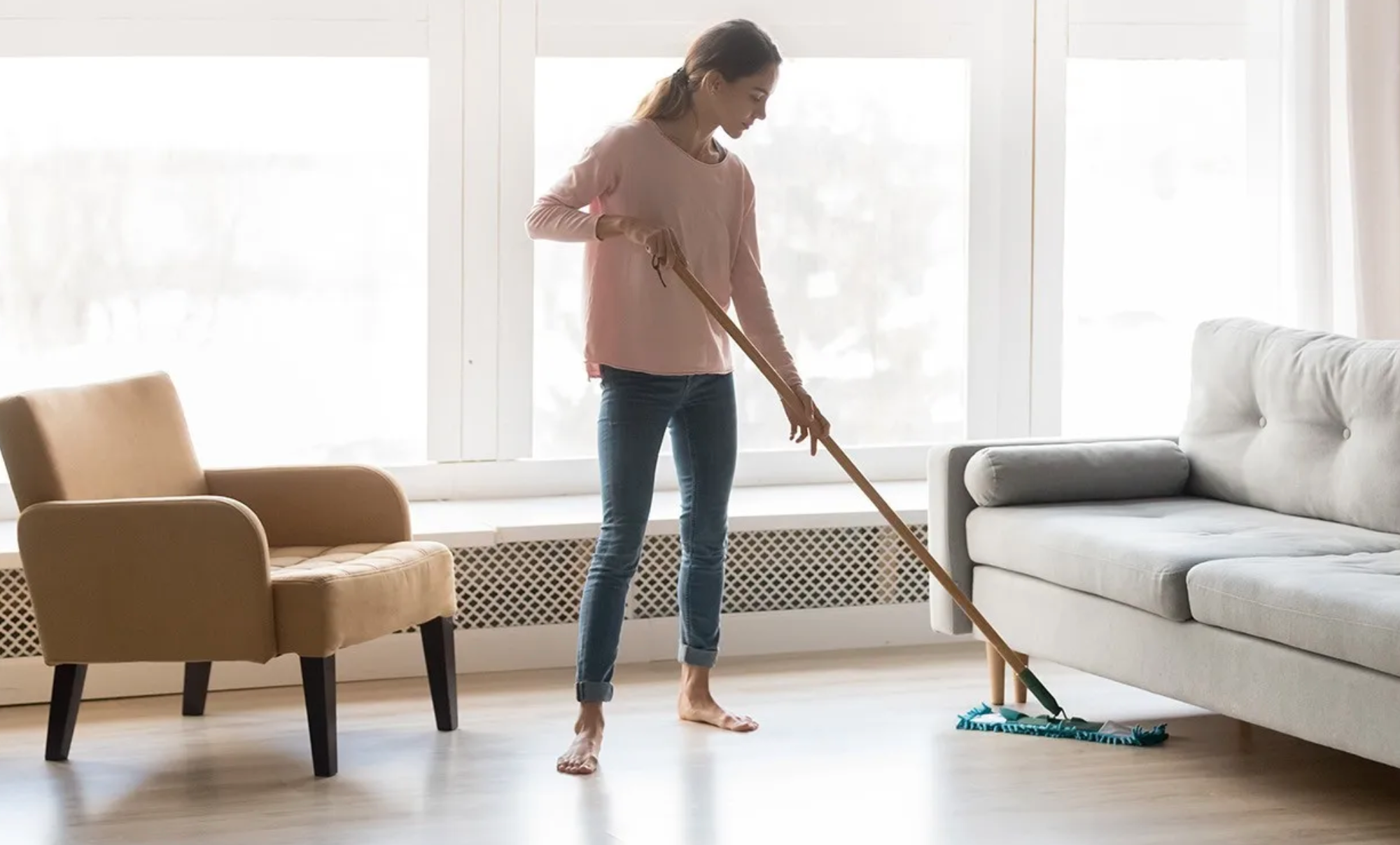 Mopping a laminate floor in a bright home
